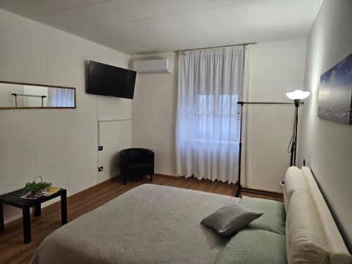 ein Schlafzimmer mit einem Bett, einem Sofa und einem Fenster in der Unterkunft Appartamenti ClesioResidenceBuonconsiglio in Trient