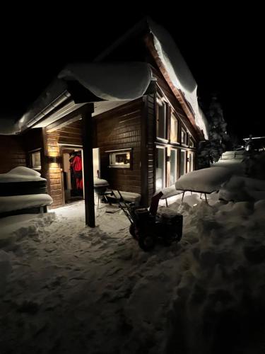 dom w śniegu z sankami przed nim w obiekcie Granfjällsporten 57 w mieście Stöten