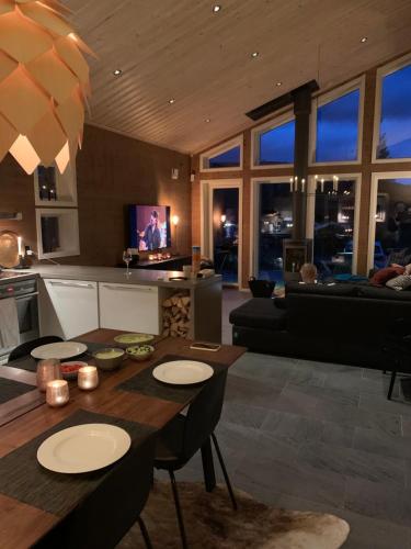 een keuken en een woonkamer met een tafel en stoelen bij Granfjällsporten 57 in Stöten