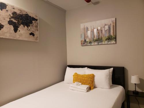 a bed in a room with two pictures on the wall at The City-Side at Silver Lake *NEW 1-BED RM APT in Providence