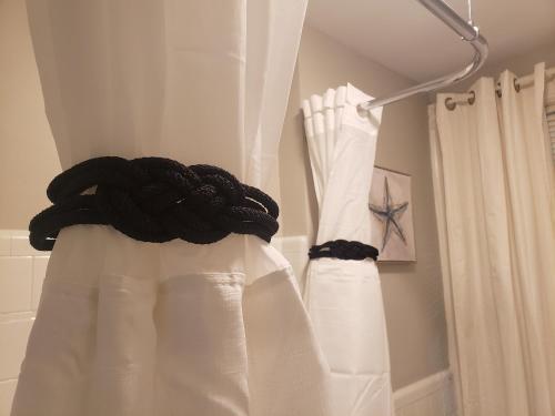 2 cortinas blancas colgando en un baño en The City-Side at Silver Lake *NEW 1-BED RM APT en Providence