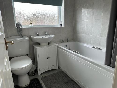 ein Badezimmer mit Toilette, Waschbecken und Badewanne in der Unterkunft Tennyson House - Cul De Sac 3 Bedroom House for Families, Business Travellers, Contractors, Free Parking & Wifi, Nice Garden in Royal Wootton Bassett
