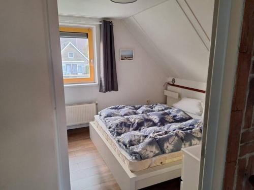 a small bedroom with a bed in a attic at Zoete Zee Huis in Medemblik