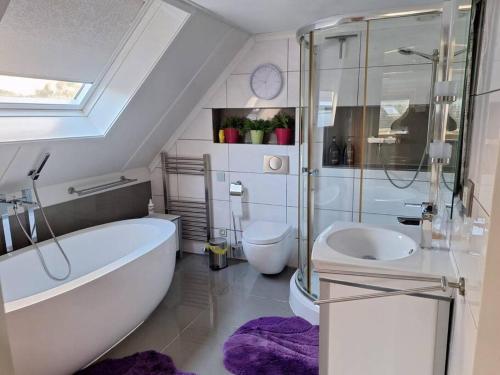 a bathroom with a tub and a toilet and a sink at Zoete Zee Huis in Medemblik