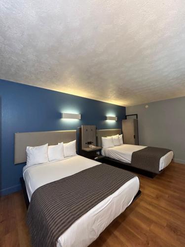 Rodeway Inn في إمبوريا: سريرين في غرفة فندق بجدران زرقاء