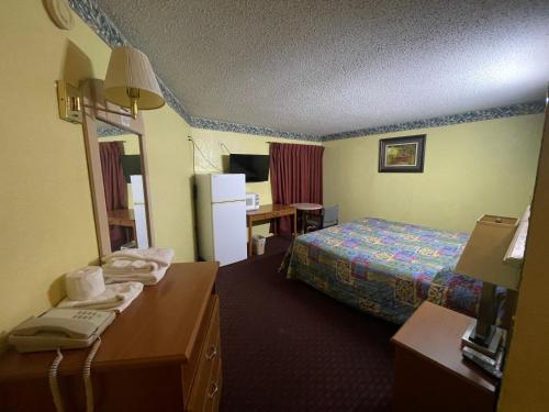 a hotel room with a bed and a desk at Relax Inn Copperas Cove in Copperas Cove