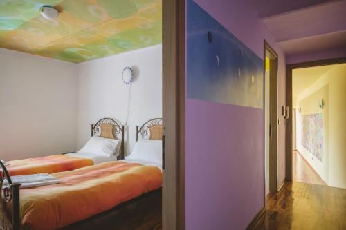 two beds in a room with a colorful ceiling at Casa del Sole in Castagnole Lanze
