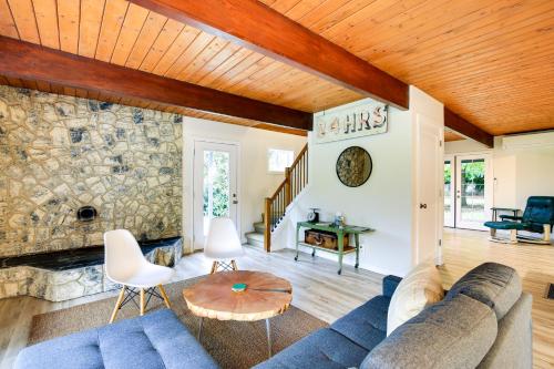 a living room with a blue couch and a stone wall at Modern Oregon Getaway with Fireplace, Yard and Deck in Boring
