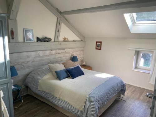 een slaapkamer met een groot bed met blauwe kussens bij la grange aux oiseaux in Arnaville