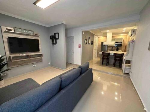 a living room with a blue couch and a television at Palmas View Premium 7 in Humacao