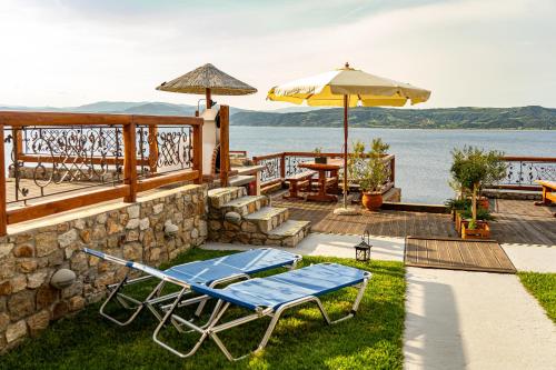 a deck with a lounge chair and an umbrella at Ammou Area in Ammouliani