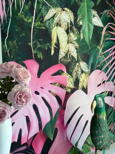 Une statue d'oiseau rose et blanc à côté des fleurs dans l'établissement Luxury & Relax Apartment, à Ottana