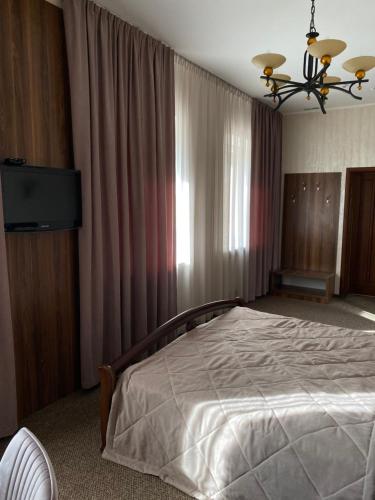 a bedroom with a large bed and a television at Status Hotel in Poltava