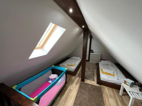 a attic room with two bunk beds and a window at Apartmani Vidatela Kopaonik in Kopaonik