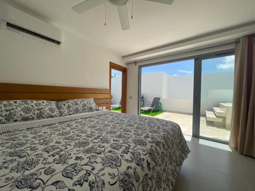 ein Schlafzimmer mit einem Bett und einem großen Fenster in der Unterkunft Los Peacocks - Premier Accommodations in Las Terrenas