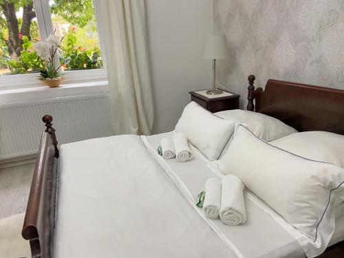 a bed with white pillows and towels on it at Holiday House Vego in Čapljina