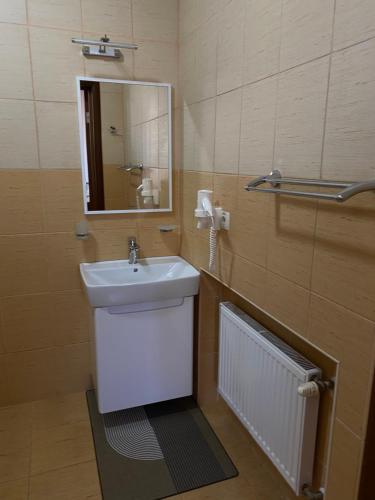 a bathroom with a sink and a mirror at Status Hotel in Poltava