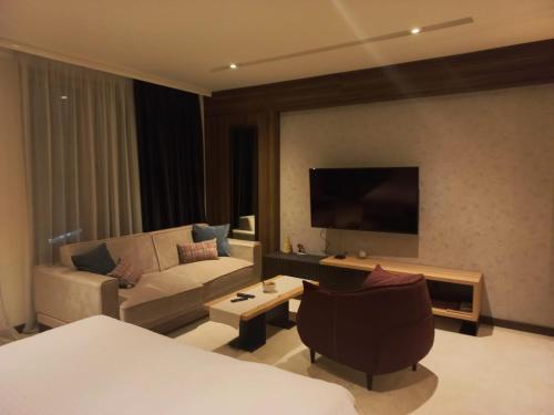 a living room with a couch and a tv at Woodside Kopaonik By Gogic in Kopaonik