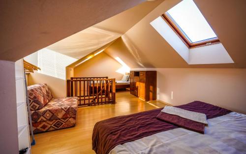 a attic bedroom with a bed and a skylight at Studio Troika in Pavčina Lehota
