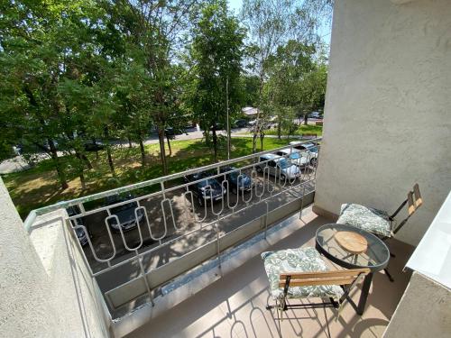 a balcony with a table and chairs and a view of a park at Ultra Central Minimal and Cozy Apartment in Bacău