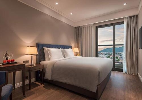 une chambre avec un grand lit et une grande fenêtre dans l'établissement Sunrise Luxury Apartment with Ocean View, à Đà Nẵng