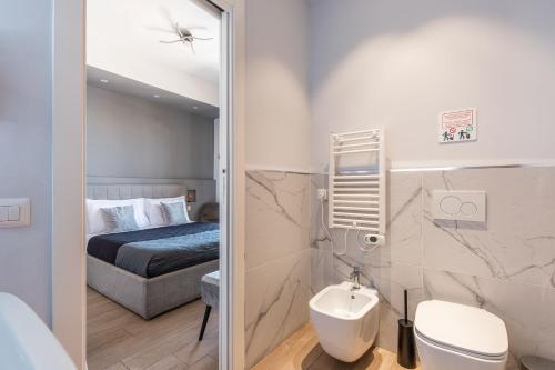 Un baño con una cama, un inodoro y un lavabo. en Capruzzi Guest House, en Bari