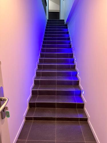 eine Treppe mit blauen Lichtern in der Unterkunft Love room borabora 6 in Trévoux