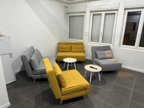 ein Wohnzimmer mit Sofas, Stühlen und Tischen in der Unterkunft Love room borabora 6 in Trévoux