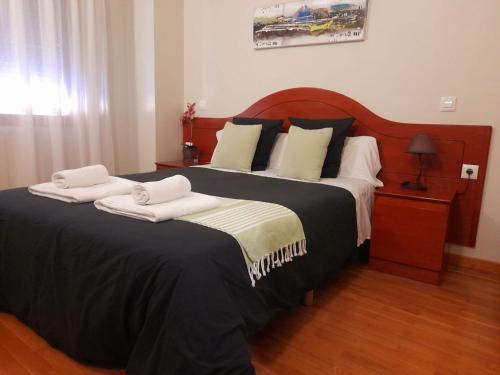 a bedroom with a large bed with two towels on it at Hotel Villa De Lerma in Lerma