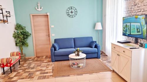 salon z niebieską kanapą i telewizorem w obiekcie Apartments Epulon w Puli
