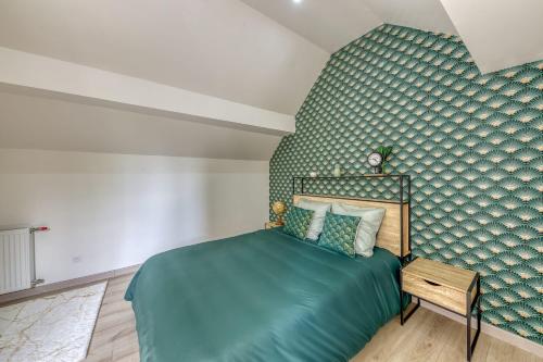 a bedroom with a bed and a green wall at Joli Appartement de vacances in Écouen