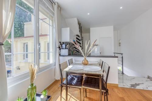 a kitchen with a table and chairs and a window at Joli Appartement de vacances in Écouen