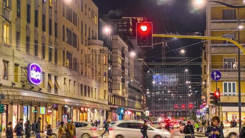 un semáforo en una concurrida calle por la noche en Hotel Aurelia Milano Centrale, en Milán