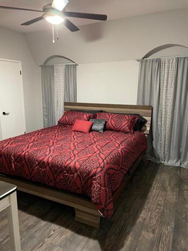 a bedroom with a bed with a red comforter at Rafeal in Houston