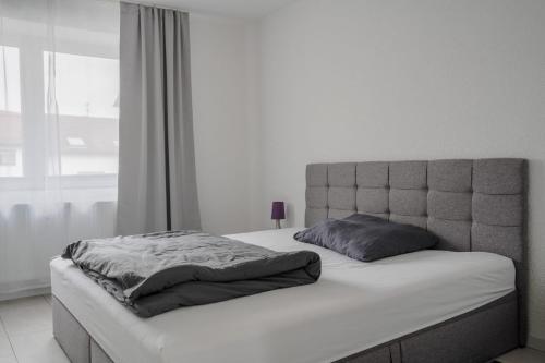 a white bedroom with a bed with a headboard at Ferienwohnung AnnA in Gries