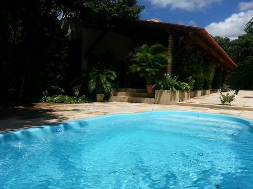a large blue swimming pool in front of a house at Casa na Faz Real in Teresina