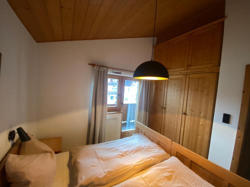 a bedroom with a bed and a lamp at Ferienwohnung HOAMAT in Going