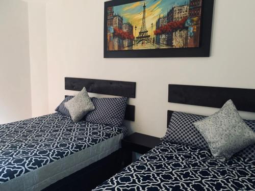 1 dormitorio con 1 cama y una pintura en la pared en ALO INN Hotel, en San Roque