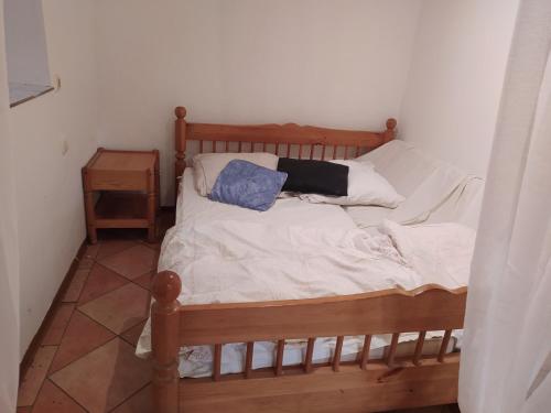 1 dormitorio con cama de madera y 2 almohadas en Ferienwohnung in 97447 Gerolzhofen,, en Gerolzhofen