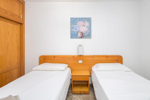 1 dormitorio con 2 camas, mesa y una foto en Lightbooking Playa Cura Mogan, en Playa del Cura