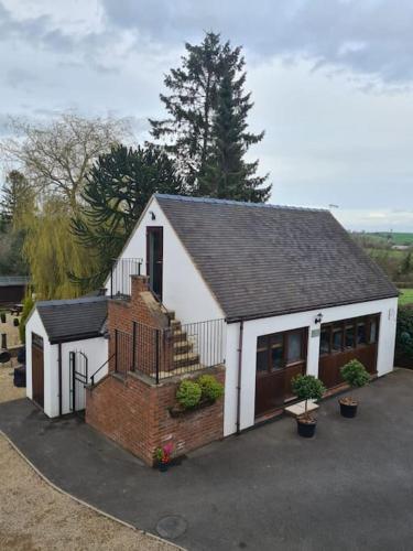 a small house with a staircase in a driveway at The Willow (Alton Towers, Animals, Peak District) in Denstone