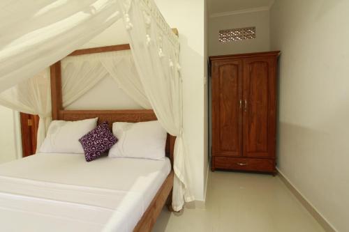 a bedroom with a bunk bed and a wooden cabinet at Suryadina Guest House in Ubud