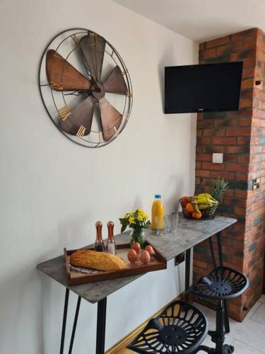 a room with a table with a clock on the wall at The Willow (Alton Towers, Animals, Peak District) in Denstone
