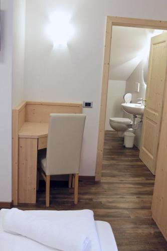 a room with a desk and a sink and a toilet at Ski Lodge Pampeago in Tesero
