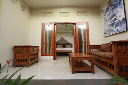 a room with two beds and a mirror at Suryadina Guest House in Ubud