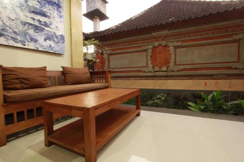 a living room with a couch and a table at Suryadina Guest House in Ubud