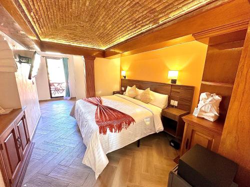 sypialnia z dużym łóżkiem i drewnianym sufitem w obiekcie Suites del Jardín Principal w mieście Guanajuato