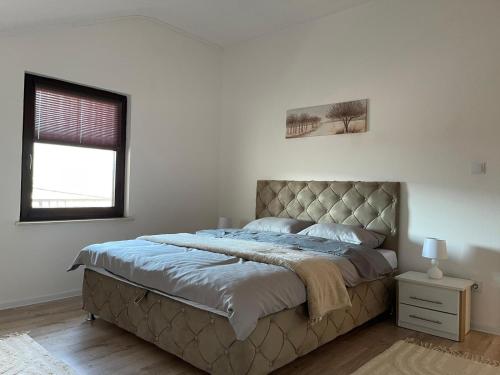 a bedroom with a large bed with a tufted headboard at Hills Holiday House in Mostar