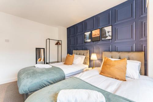 two beds in a room with blue walls at Stylish House - Close to City Centre - Free Parking, Super-Fast Wifi and Smart TVs by Yoko Property in Coventry
