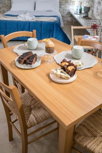 een houten tafel met borden met eten erop bij Charmeroom dimora d'incanto in Trani